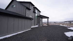 View of snowy exterior with board and batten siding