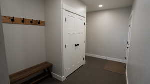 Mudroom with baseboards, dark colored carpet, and recessed lighting