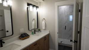 Bathroom featuring double vanity, a marble finish shower, and a sink