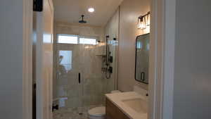 Bathroom with a shower stall, toilet, and vanity