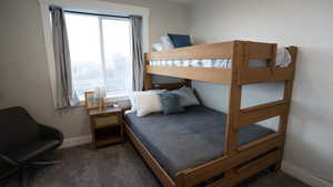 Bedroom with baseboards and dark carpet