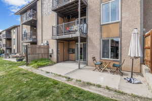 Rear view of house featuring stucco siding, fence, and a patio