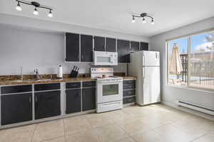Large kitchen with bright windows and track lighting.