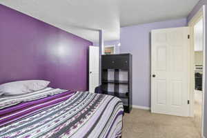 Bedroom featuring a textured ceiling and light colored carpet