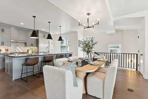 Dining room with dark wood-style floors, a chandelier, and recessed lighting