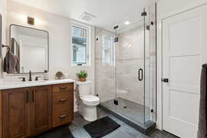 Bathroom featuring vanity, tile patterned flooring, a shower stall, and recessed lighting