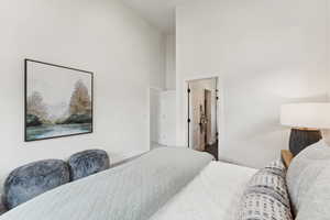 Bedroom featuring a towering ceiling and baseboards