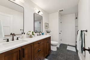 Bathroom featuring double vanity and an enclosed shower