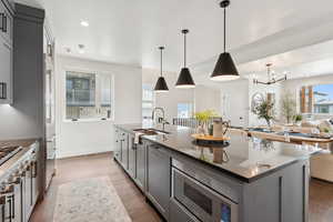 Kitchen featuring gray cabinets, wood finished floors, healthy amount of natural light, and recessed lighting