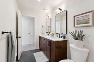 Bathroom featuring double vanity and toilet