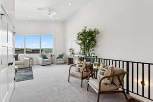Living area featuring carpet floors, a ceiling fan, a high ceiling, and recessed lighting