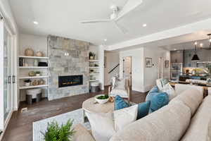 Living room with a fireplace, ceiling fan, recessed lighting, and wood finished floors