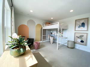Bedroom featuring recessed lighting, arched walkways, and carpet flooring
