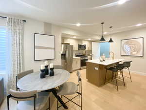 Dining space featuring light wood-type flooring, baseboards, and recessed lighting