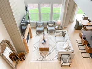 Living room with light wood-type flooring, visible vents, baseboards, and plenty of natural light