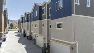 Exterior space featuring a garage, stone siding, stucco siding, and board and batten siding