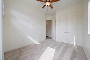 Unfurnished bedroom with carpet floors, a closet, and baseboards