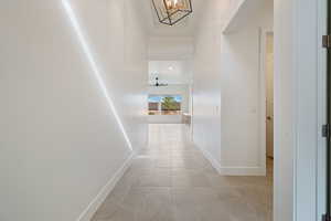 Hallway with baseboards and light tile patterned floors