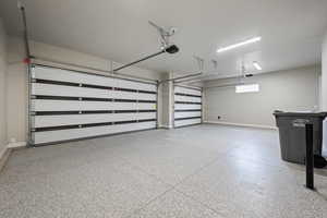 Garage with baseboards and a garage door opener