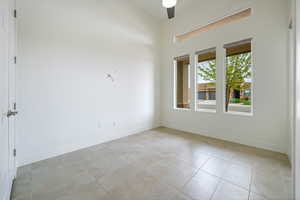 Unfurnished room featuring baseboards, a ceiling fan, and light tile patterned flooring