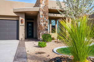 Entrance to property featuring stone siding and stucco siding