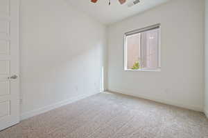 Empty room with ceiling fan, baseboards, visible vents, and carpet