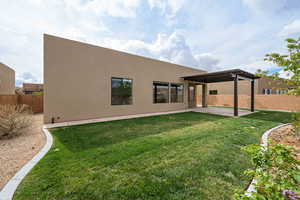 Back of property with fence, a pergola, a patio, and stucco siding