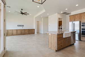 Kitchen featuring a sink, visible vents, ceiling fan, light stone countertops, and appliances with stainless steel finishes