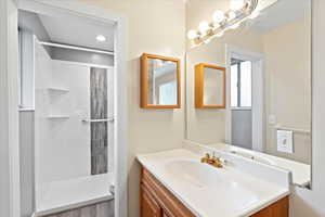 Bathroom with a tile shower, toilet, and vanity