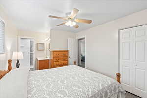 Bedroom with carpet, ceiling fan, connected bathroom, and a closet