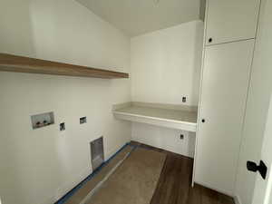 Washroom with baseboards, cabinet space, washer hookup, and dark wood-style floors