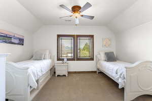 Bedroom featuring light carpet, visible vents, vaulted ceiling, and a ceiling fan