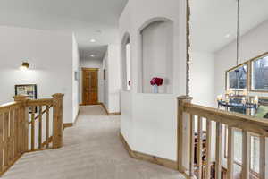 Hall with baseboards, a chandelier, recessed lighting, an upstairs landing, and light colored carpet