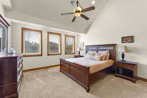 Bedroom featuring baseboards, ceiling fan, light colored carpet, and vaulted ceiling
