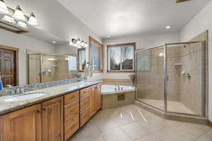 Full bathroom featuring a shower stall, tile patterned floors, a bath, and a sink
