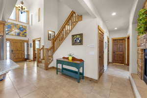 Entryway featuring recessed lighting, a notable chandelier, light tile patterned floors, and stairs