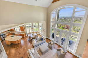 Living room with baseboards, high vaulted ceiling, and dark wood-style flooring