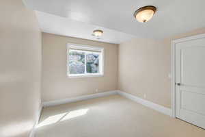 Carpeted empty room with baseboards