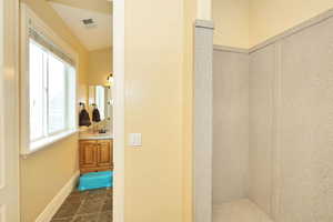 Bathroom with baseboards, visible vents, and vanity