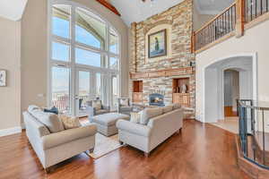 Living area featuring wood finished floors, a high ceiling, and a healthy amount of sunlight