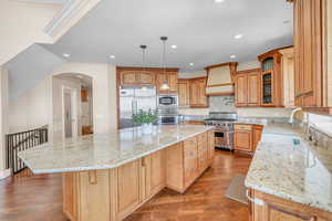 Kitchen featuring a sink, built in appliances, a large island, premium range hood, and recessed lighting