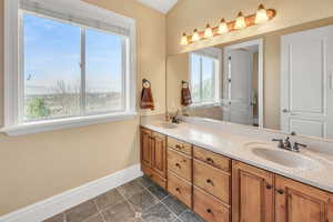 Full bathroom with baseboards, a sink, and double vanity