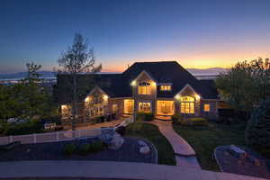 View of front of house with stone siding, a front yard, fence, and a mountain view