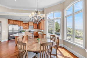 Dining space with baseboards, crown molding, a chandelier, and dark wood-type flooring