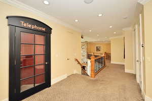 Hallway with baseboards, recessed lighting, carpet, an upstairs landing, and crown molding