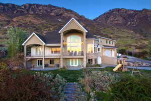 Back of property with french doors, a mountain view, a playground, an attached garage, and a patio