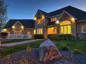 Craftsman inspired home featuring stone siding, a front lawn, and a shingled roof