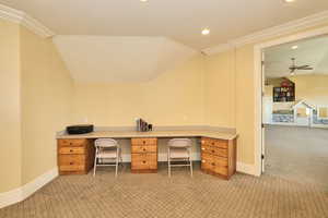 Unfurnished office featuring light carpet, vaulted ceiling, built in study area, and recessed lighting
