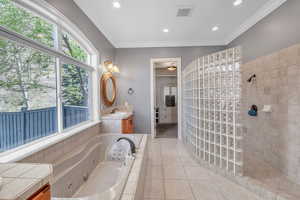 Full bathroom featuring a healthy amount of sunlight, visible vents, walk in shower, a whirlpool tub, and tile patterned flooring