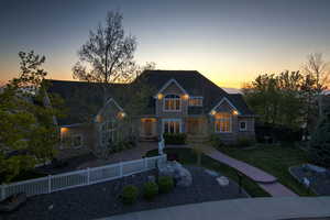View of front of property with a lawn, stone siding, and fence private yard